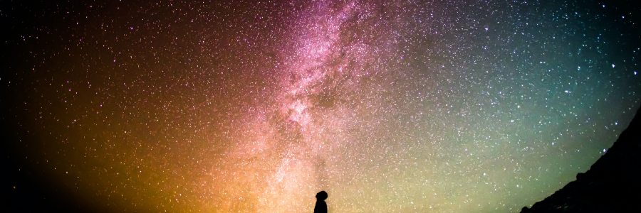 Silohouetted person looking up at night sky