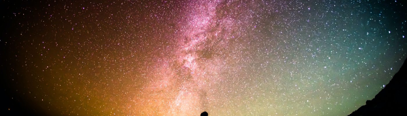 Silohouetted person looking up at night sky